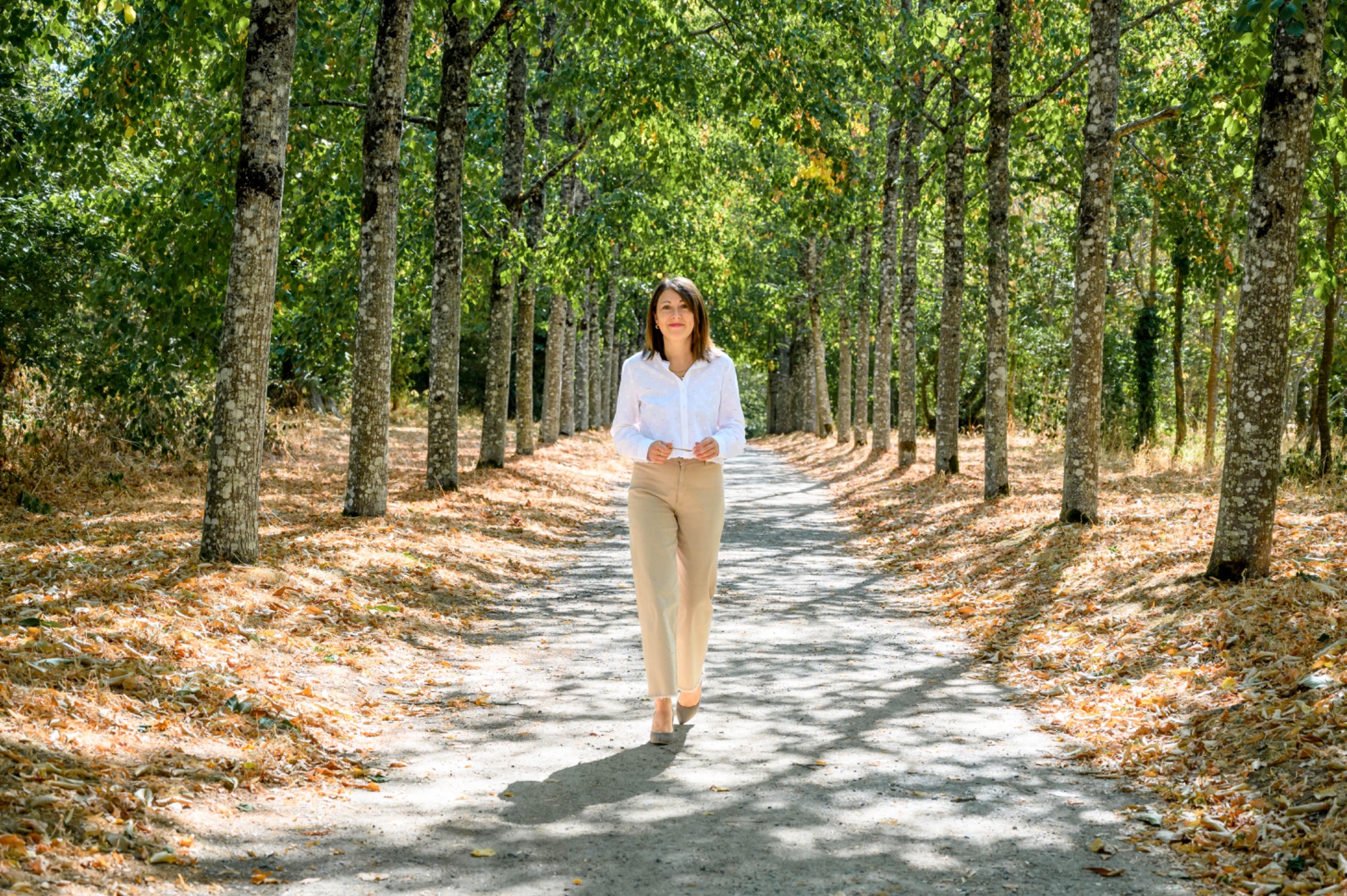 Charlène BARRE, fondatrice d’Italimmo Invest, marchant dans une allée arborée en Italie